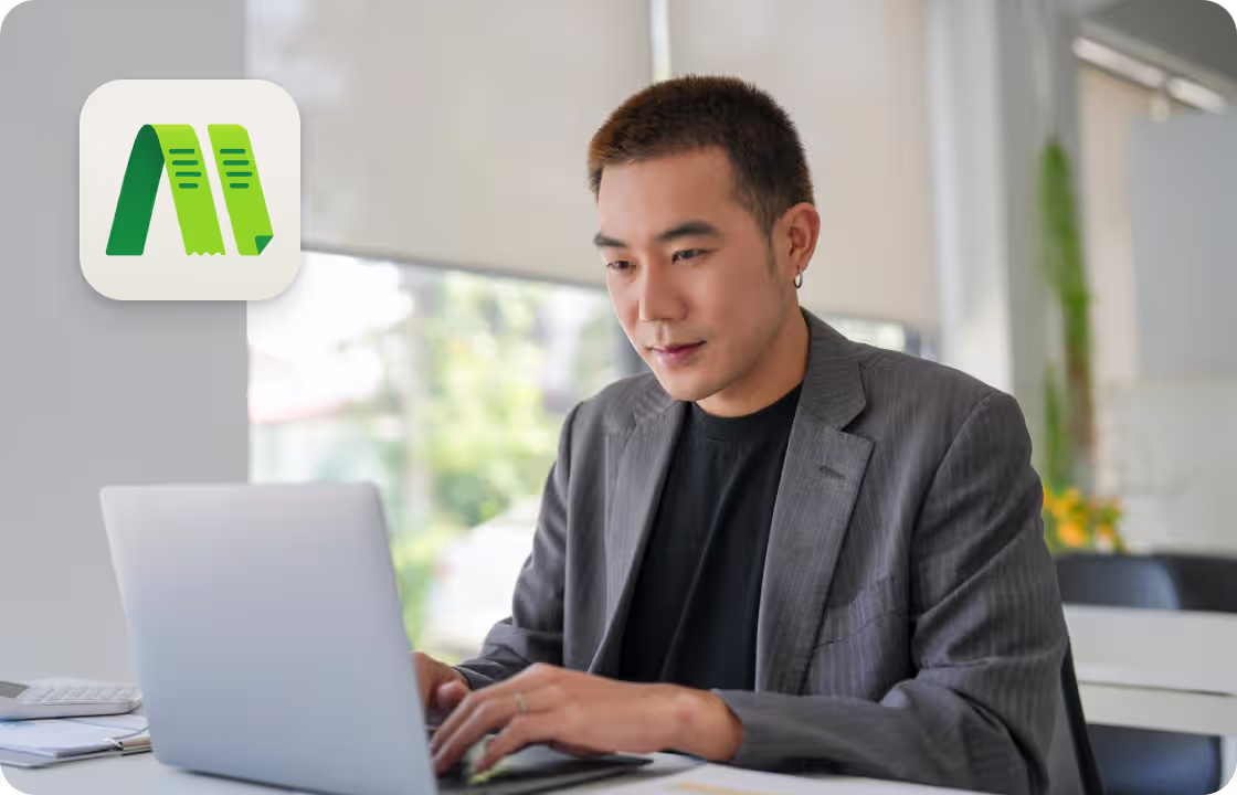 A man works on a laptop at a clean desk, with the ccMonet logo. It shows how our AI - powered finance tools (bookkeeping, dashboards) and expert services (tax compliance, business support) help professionals manage finances efficiently in a modern workspace.